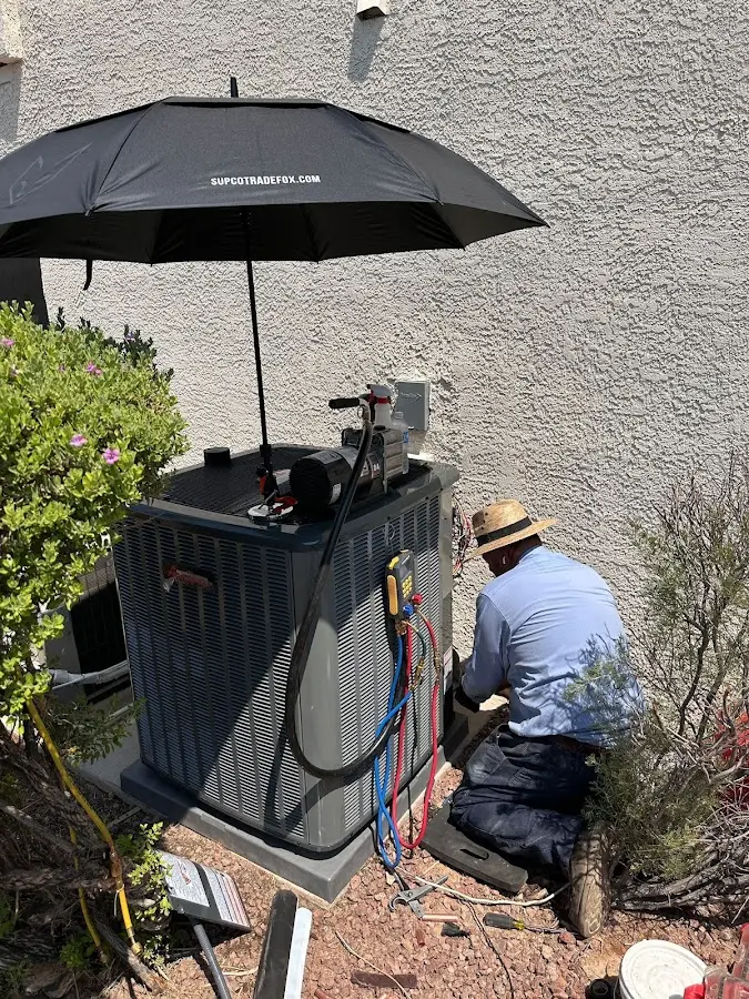 HVAC technician performing outdoor AC maintenance in Clarkdale