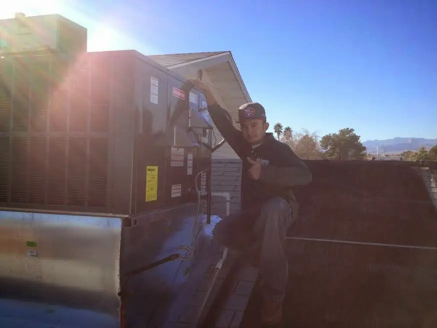HVAC technician performing Heat Pump Repair on a rooftop unit in Clarkdale